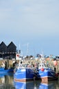 Fishing Boats in Whitstable Harbour in portrait view with warehouse in background