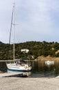 Fishing boats and a yacht on the pier against the backdrop of the sea and mountains