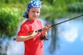 Fishing. Boy fisherman with fishing rod on lake. Portrait of child with spinning in hands on river background