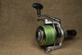 Fishing, carp reel with fishing linel on the background of burlap . Burlap