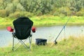 Fishing chair, rod and bait on the river bank Royalty Free Stock Photo