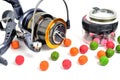 Fishing coil, colored boilies, braided cord, on white background