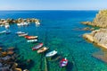 Fishing colorful boats on transparent water in small harbor of Riomaggiore village National park Cinque Terre