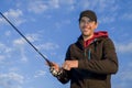 Happy smiling fisherman on clouds background