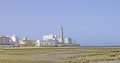 Fishing corrals at low tide on the beach with the Chipiona lighthouse in the background, Cadiz, Andalusia, Spain. Andalusian Royalty Free Stock Photo