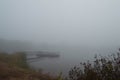 A fishing dock on a dark, foggy, autumn morning by the lake Royalty Free Stock Photo