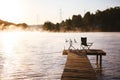 Fishing equipment on seat on lake. Feeder carp rods on wooden pier Royalty Free Stock Photo