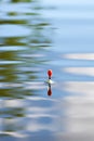 Fishing float on water with waves and beautiful reflection Royalty Free Stock Photo