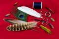 Fishing Fly Tying Feathers and Tools on a Mottled Red Table Top Royalty Free Stock Photo