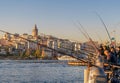 Fishing at golden horn on Galata Bridge before sunset with Galata Tower in the background, Eminonu district, Istanbul, Turkey Royalty Free Stock Photo