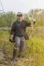 Fishing. Happy fisherman holding pike fish trophy and fishing rod at river Royalty Free Stock Photo