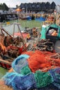 WHITSTABLE, UK - OCTOBER 15, 2017: The fishing Harbor with colorful fishing nets in the foreground and wooden huts in the backgrou Royalty Free Stock Photo