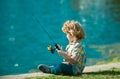 Fishing hobby. Boy with spinner at river. Kid at jetty with rod.