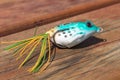 Fishing hook with a bayman in the shape of a frog. Fishing bait on green cloth background. Royalty Free Stock Photo