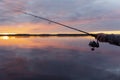 Fishing on the lake at the sunset. Hands of fisherman with fishing rod. Macro shot. Fishing rod and hands of fisherman over lake w Royalty Free Stock Photo