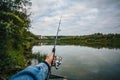 Fishing on a lake at sunset. Fishing rod with a reel in hand Royalty Free Stock Photo