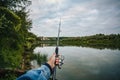 Fishing on a lake at sunset. Fishing rod with a reel in hand Royalty Free Stock Photo