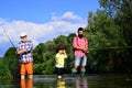 Fishing. Little boy fly fishing on a lake with his father and grandfather. Grandfather and father with cute child boy Royalty Free Stock Photo