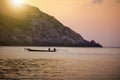 Fishing man on floating long tail boat behind island and sunset Royalty Free Stock Photo