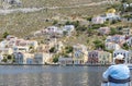 A Fishing Man Sitting on a Chair by the Main Port of Symi, Greece, With His Fishing Rod Royalty Free Stock Photo