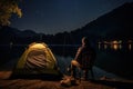 Fishing Man is Sitting at Night by Lake, Fishing Chair, Outdoor Tent, Fisherman Holds a Fishing Rod Royalty Free Stock Photo