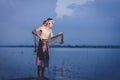 Fishing man use throwing net to catch fish in lake Royalty Free Stock Photo