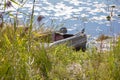 Fishing metal boat tethered by the river on a sunny day.