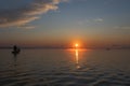 Fishing morning. Colorful sunrise at lake with silhouettes of fishing boats with fishermen