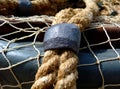 Fishing net closeup with gray lead weights attached and fishing boat