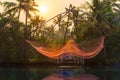 Fishing net glowing red, raised at sunset in Kerala, India Royalty Free Stock Photo