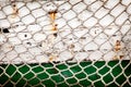 Fishing net on old green and white painted ship board background Royalty Free Stock Photo
