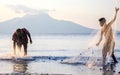 Fishing nets in the sunset, local Fisherman and young apprentice, Flores, Indo, Asia