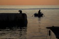 Fishing on orange blue sea on sunrise