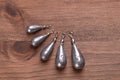 Fishing pear leads, also called sinkers, on a dark brown wood board