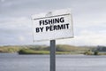 Fishing by permit sign at fresh water lake