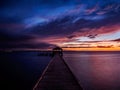 Fishing pier and dock silhouetted in a colorful sunset