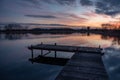 Fishing pier over a calm lake and beautiful sunset on the sky Royalty Free Stock Photo