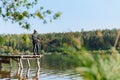 Fishing for pike, perch, carp. Fisherman with rod, spinning reel on river bank. Man catching fish, pulling rod while fishing on Royalty Free Stock Photo