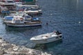 Fishing and pleasure boats are moored at the stone pier. Leisure and business at sea on a sunny day Royalty Free Stock Photo