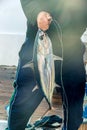 Fishing and poaching, caught a large tuna fish in the hand of an angler. Vertical frame Royalty Free Stock Photo