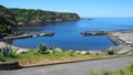 Fishing port and coastal cliffs, blooming hortensia bushes in the forefront, Porto Formoso, Sao Miguel, Azores Royalty Free Stock Photo