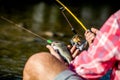 Fishing Reel. Fishing Rod with Aluminum Body Spool. Man hold big fish trout in his hands. Fisherman and trophy trout Royalty Free Stock Photo