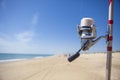 Fishing reel on rod detail with angling fishers at bottom on the Royalty Free Stock Photo