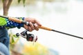 Fishing reel and rod in fisherman hand in a pond Royalty Free Stock Photo
