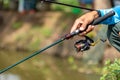 Fishing reel and rod in fisherman hand in a pond Royalty Free Stock Photo