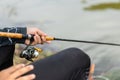 Fishing reel and rod in fisherman hand in a pond Royalty Free Stock Photo