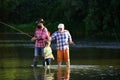 Fishing in river. Father teaching his son fishing against view of river and landscape. Young - adult concept. Father Royalty Free Stock Photo