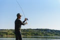 Fishing in river.A fisherman with a fishing rod on the river bank. Man fisherman catches a fish pike.Fishing, spinning reel, fish Royalty Free Stock Photo