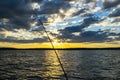 Fishing road silhouette during sunset. Fishing pole against ocean at sunset. Fishing rod in a saltwater boat during fishery day in