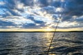 Fishing road silhouette during sunset. Fishing pole against ocean at sunset. Fishing rod in a saltwater boat during fishery day in